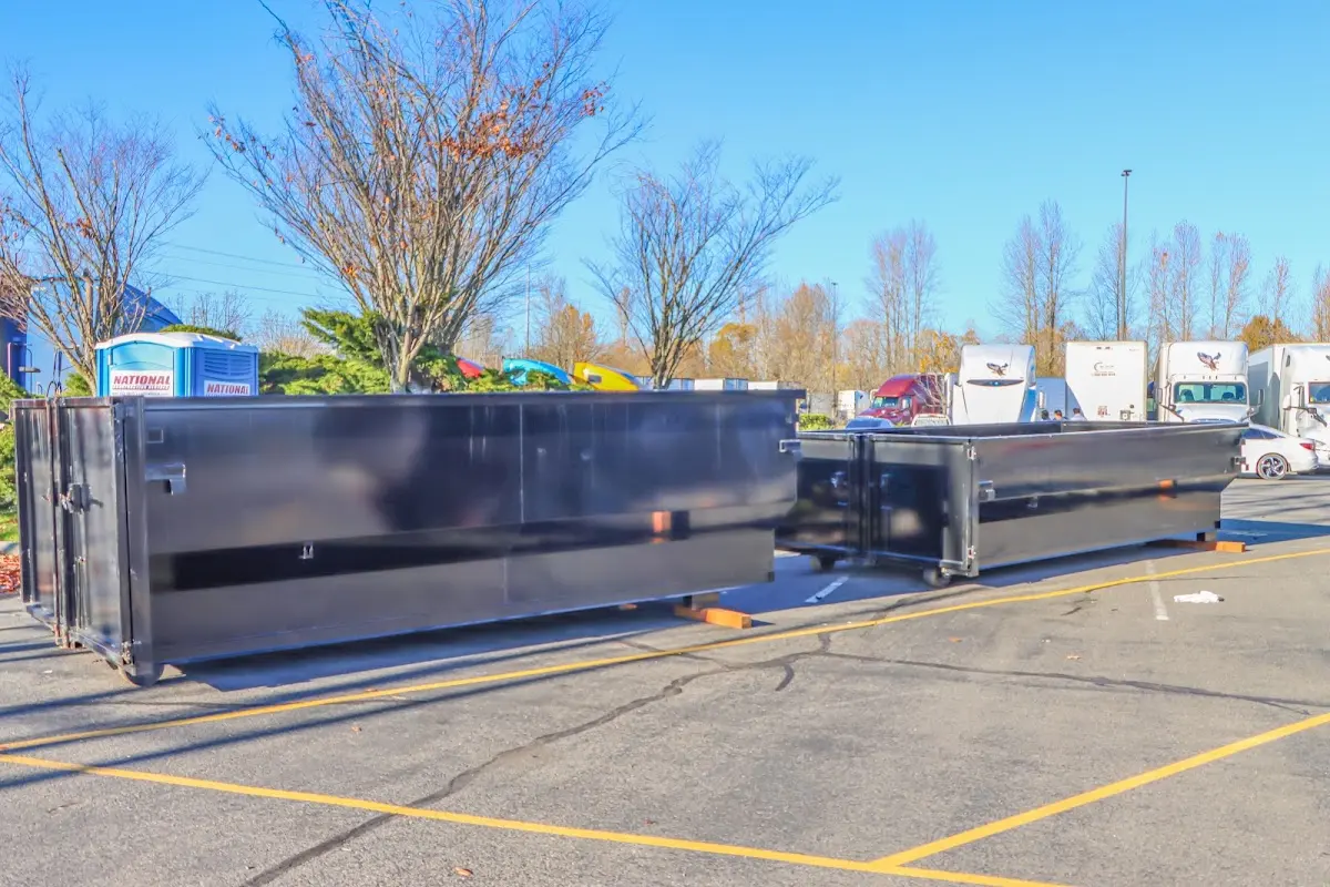 Professional dumpster rental service with roll-off container on residential driveway in Isanti